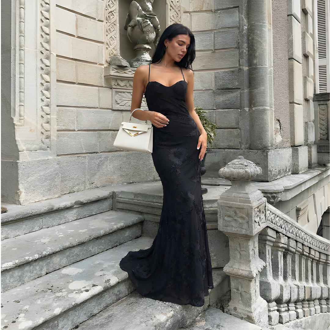 Black lace maxi evening dress with open-back design and flowing floor-length skirt